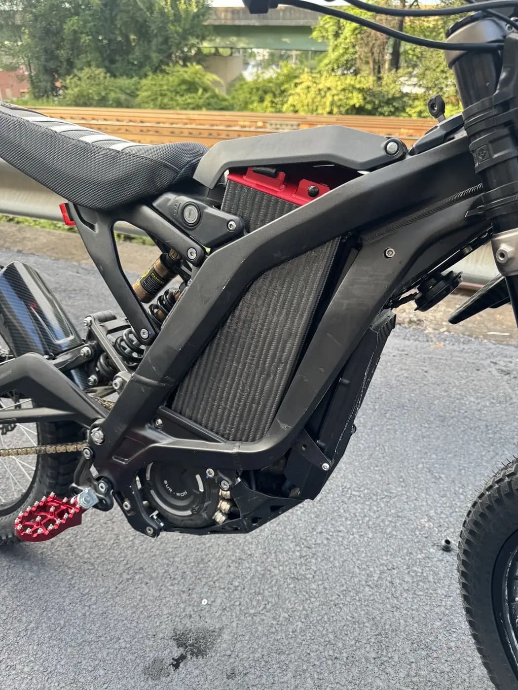 Close view of the LB 60/60 seated in the Sur-Ron frame, carbon fiber case flush between the frame rails