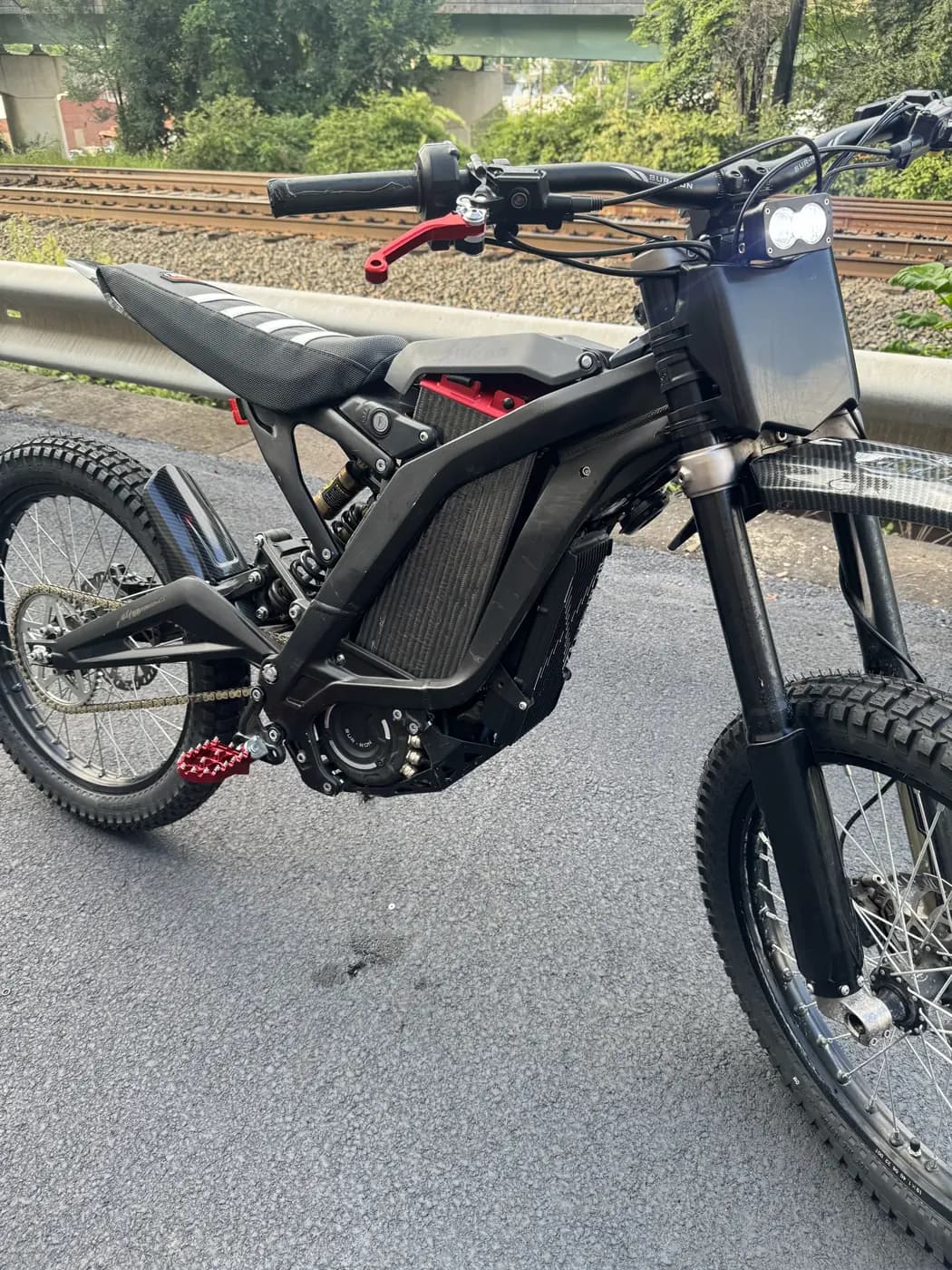 Sur-Ron Light Bee with the SPM LB 60/60 installed in the frame, parked beside railroad tracks