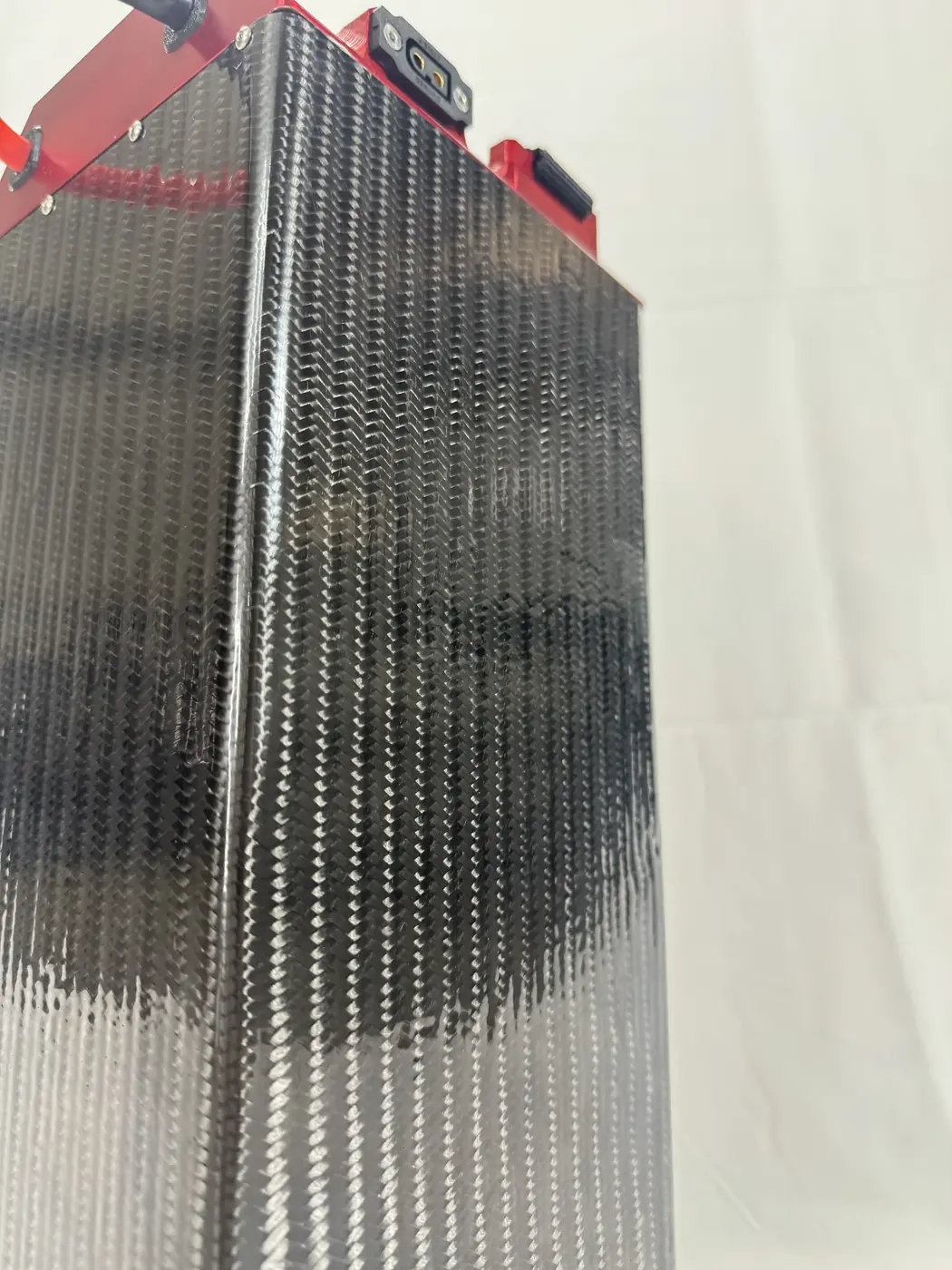 Macro of the LB 60/60's carbon fiber case, showing the woven texture and vertical ribs